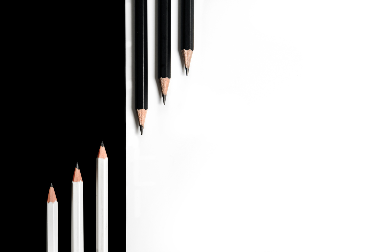 black pencils on a white background and white pencils on a black background